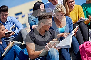 Students outside sitting on steps