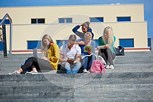 Students outside sitting on steps