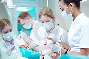 Students practicing on an artificial jaw and a dummy