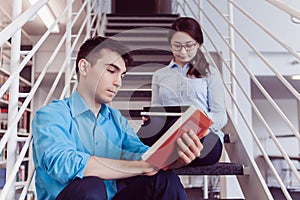 Students reading book together in the library