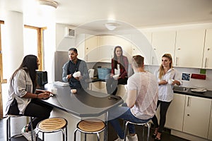 Students Relaxing In Kitchen Of Shared Accommodation photo