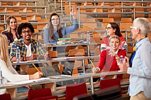 Students rising hands to answer the question in lecture