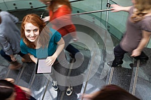 Students rushing up and down a busy stairway -