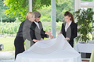 Students setting up tablecloth next to manager