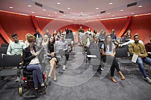 Students sit facing camera in a modern university classroom