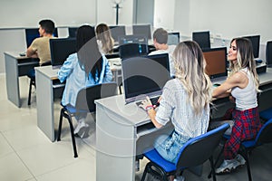 Students sitting in a classroom, using computers during class