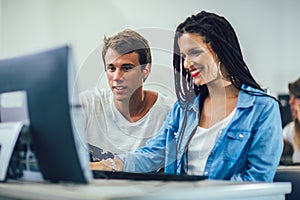 Students sitting in a classroom, using computers during class