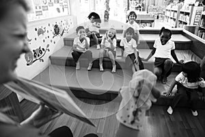 Students sitting on the floor listening to story te