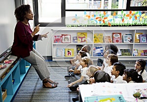 Students sitting on the floor listening to teacher