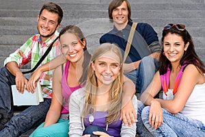 Students sitting on school stairs smiling teens