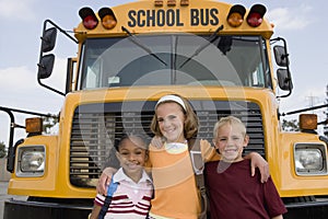 Students Standing In Front Of School Bus