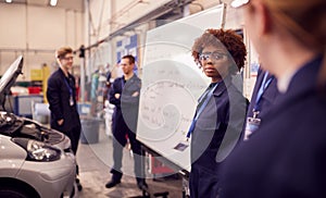 Students Studying For Auto Mechanic Apprenticeship At College Standing By Whiteboard