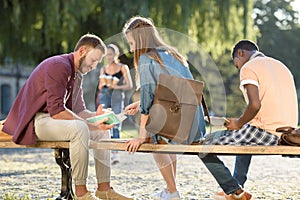 Students studying on bench in park