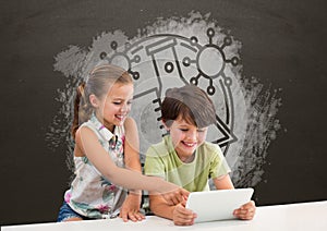 Students at table using a tablet against grey blackboard with school and education graphic