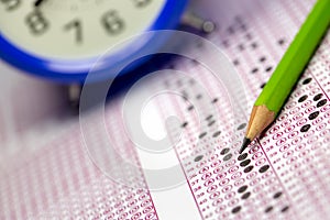 Students taking exams, writing examination room with holding pencil on optical form of standardized test with answers paper photo