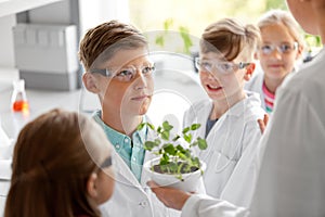 Students and teacher with plant at biology class