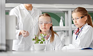 Students and teacher with plant at biology class