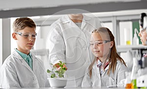 Students and teacher with plant at biology class