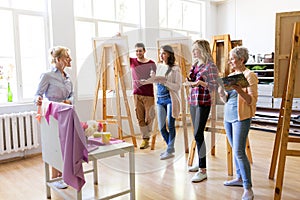 Students and teacher with still life at art school