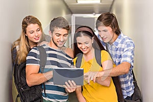 Students using digital tablet at college corridor