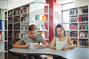 Students using digital tablet in library