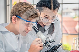 Students using microscope in science laboratory class