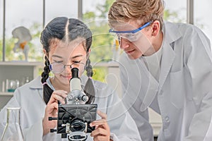 Students using microscope in science laboratory class