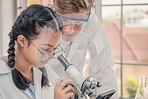 Students using microscope in science laboratory class