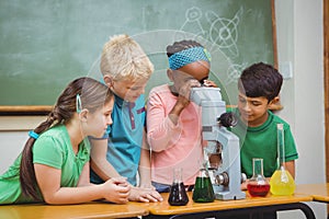 Students using science beakers and a microscope