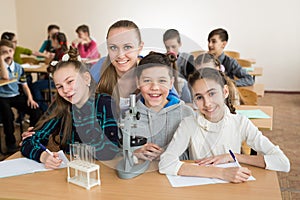 Students using science beakers and a microscope at the elementary school.