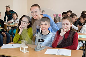 Students using science beakers and a microscope at the elementary school.