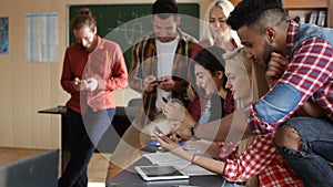 Students using smart phone sitting desk university classroom