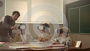 Students using vr glasses. teacher helping pupils to learn science with gadgets