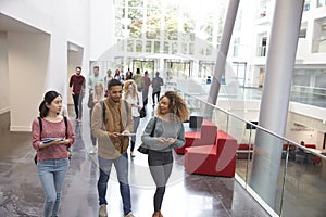 Students walk and talk using mobile devices in university