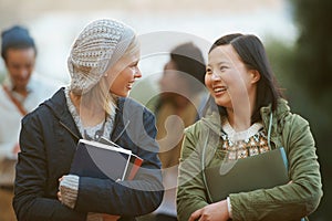 Students, women and friends outdoor on campus for university, conversation and walking to class with smile. College