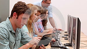 Students working in computer room with lecturer