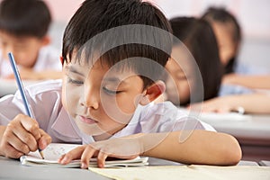 Students Working At Desks In Chinese School