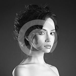 Studio art portrait of beautiful woman with elegant hairstyle on black background.