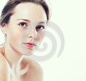 Studio beauty. Portrait of smiling young and happy woman with freckles. Isolated on white.