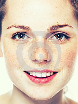 Studio beauty. Portrait of smiling young and happy woman with freckles. on white.