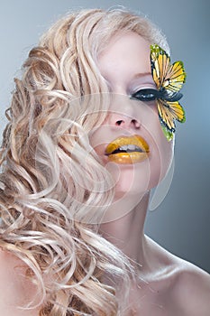 Studio beauty portrait with yellow butterfly