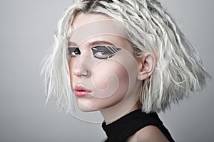 Studio beauty portrait of young woman with black graphic makeup.