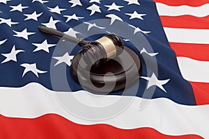 Studio close up shot of a judge gavel over flag of United States of America