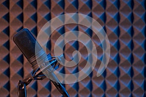 Studio condenser microphone on acoustic foam panel background