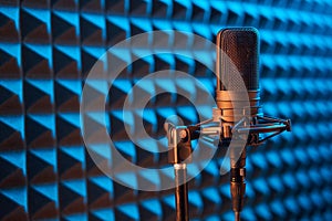 Studio condenser microphone on blue acoustic foam panel background