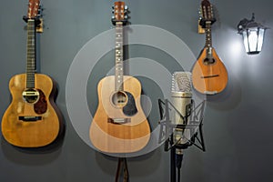 A studio condenser microphone in front of guitars