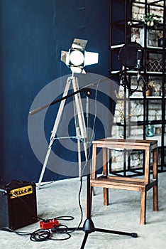 Studio condenser microphone with pop filter and anti-vibration mount live recording. Blue wall, speaker and decorative