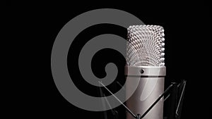 The Studio Condenser Microphone Rotates on a Black Background Close-Up