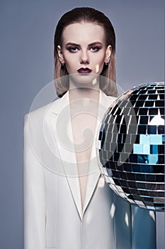 Studio fashion photo of young elegant woman in white men`s jacket