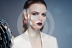 Studio fashion photo of young elegant woman in white men`s jacket